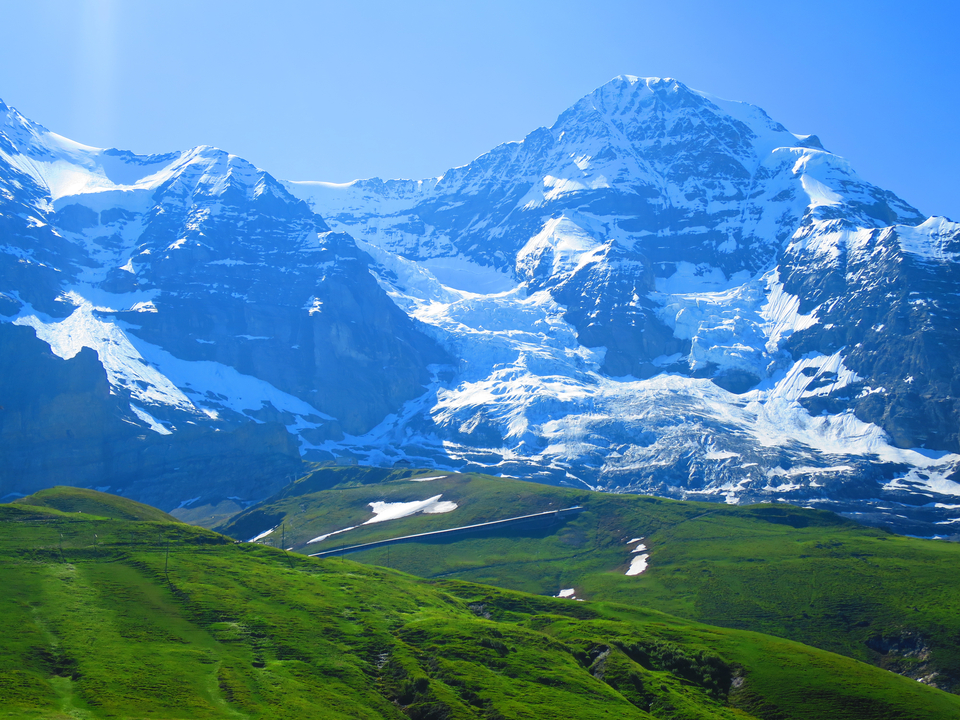 Des montagnes enneigées dans un ciel bleu clair.