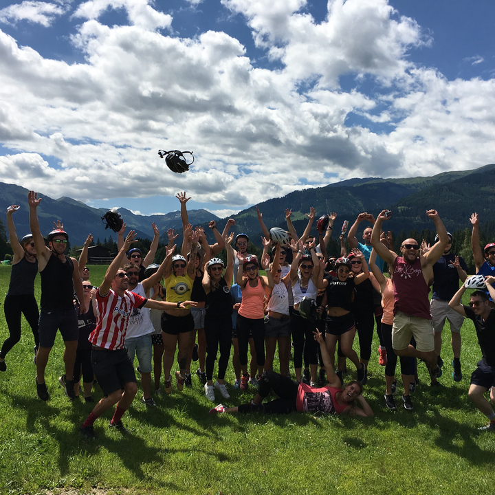 Un grand groupe saute joyeusement sur fond de montagnes pittoresques.