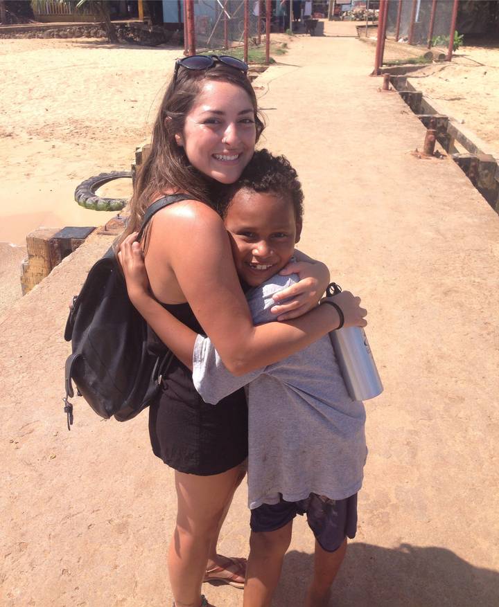 Woman hugging a child on a concrete pier.