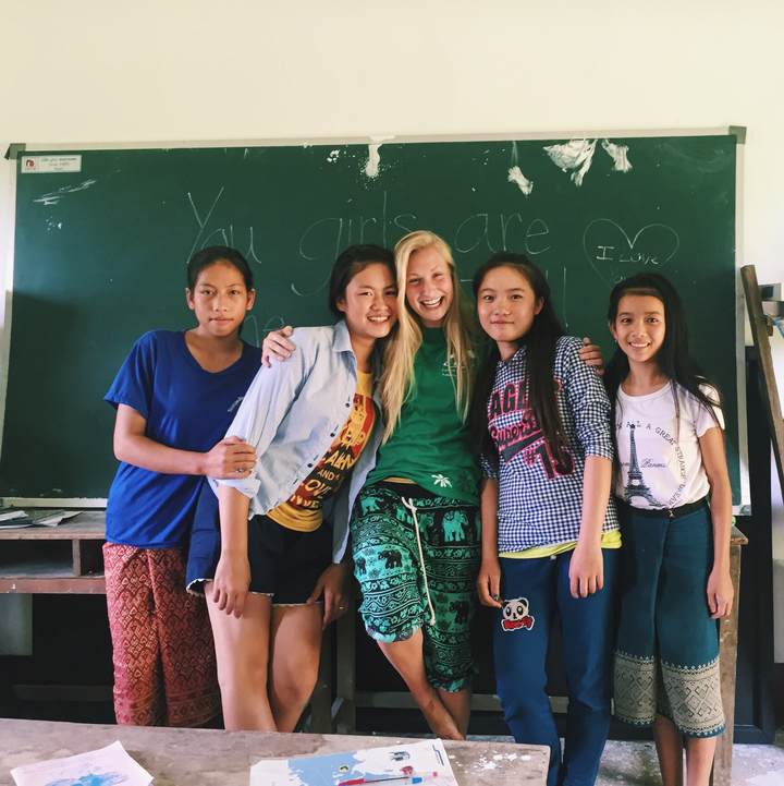 Group of students posing in front of a chalkboard.