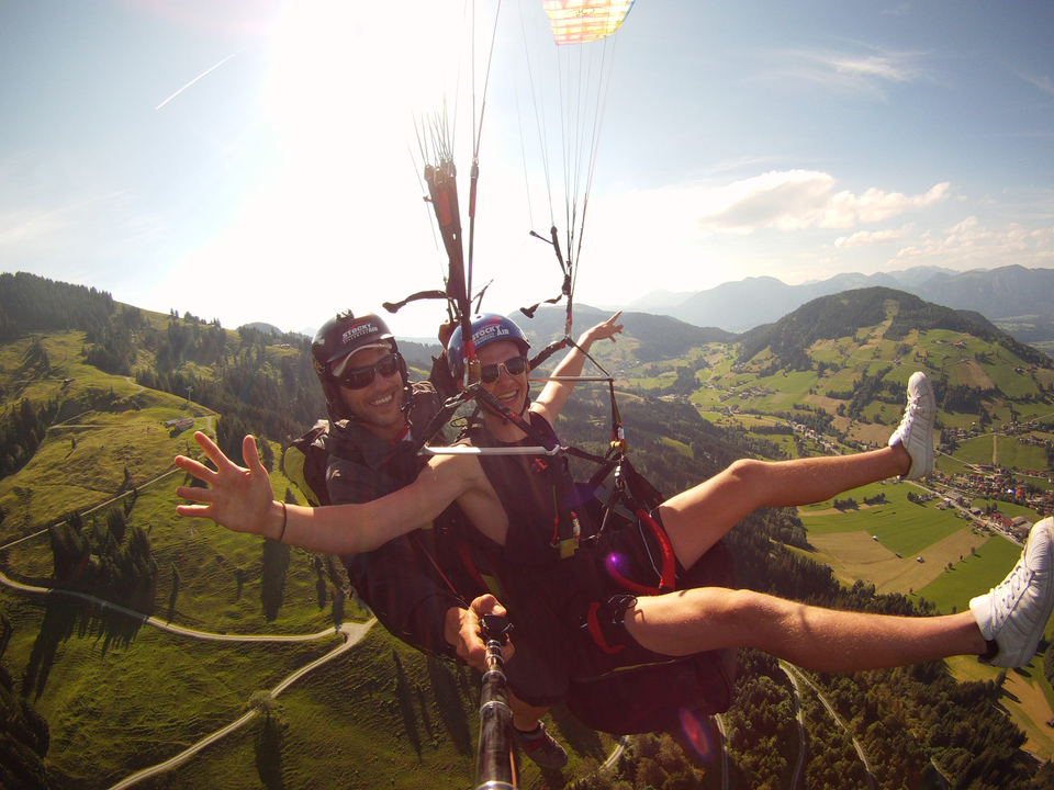 Deux personnes survolant un paysage pittoresque en parapente.