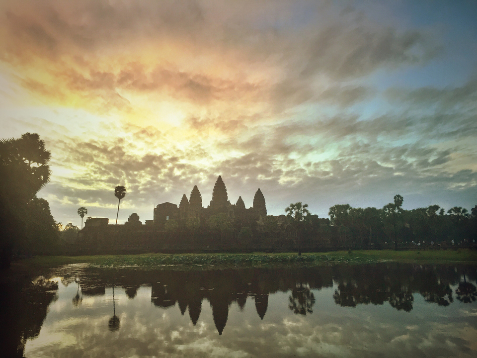 Scenic view of Angkor Wat at sunrise with reflection.
