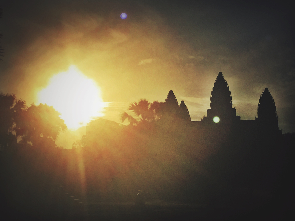 Sunset behind ancient temple silhouettes.
