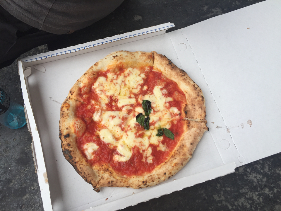 Une pizza Margherita classique dans une boîte.