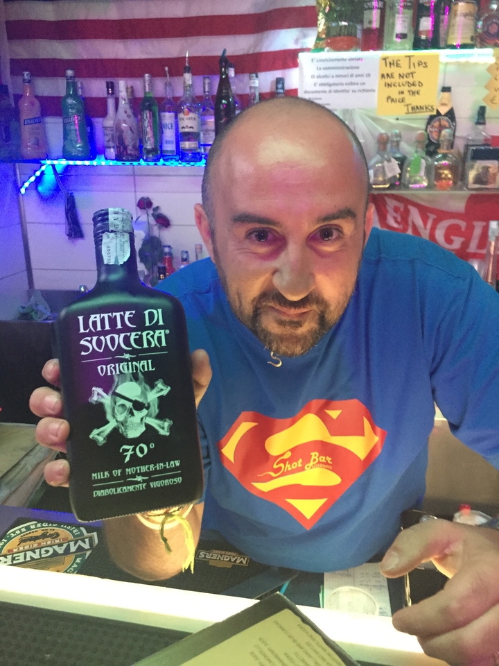 Homme tenant une bouteille avec l'étiquette "Latte di Suocera".