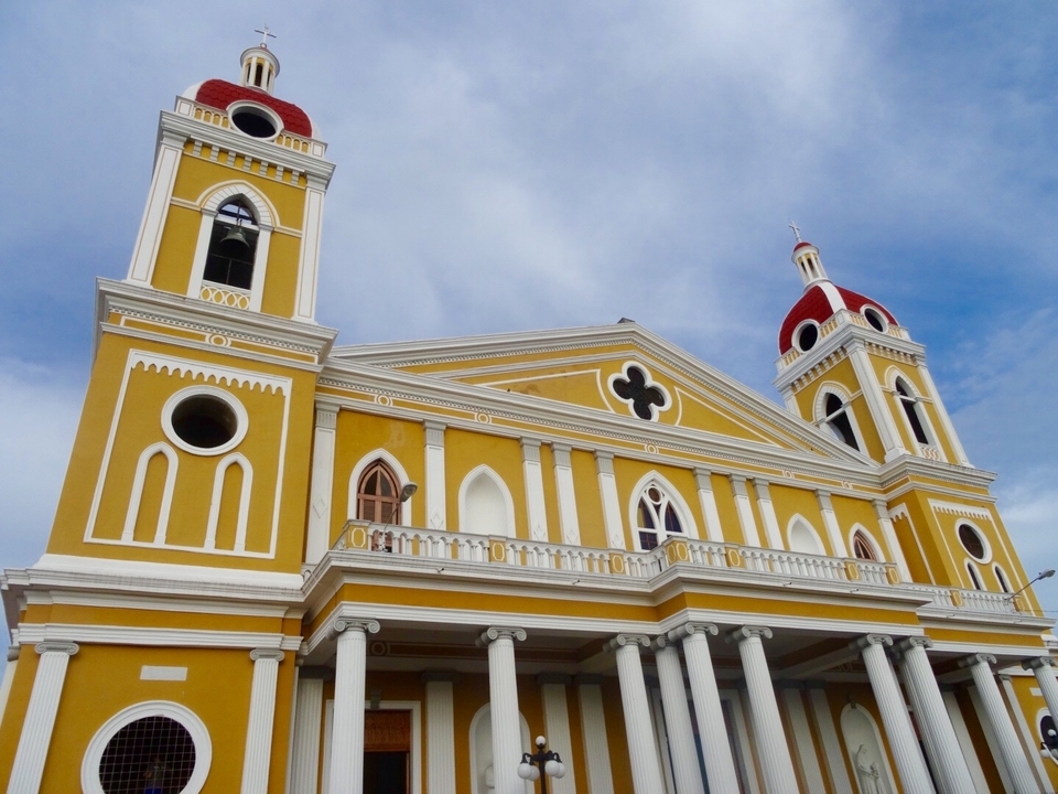 Une façade de cathédrale colorée avec deux clochers à dôme rouge.