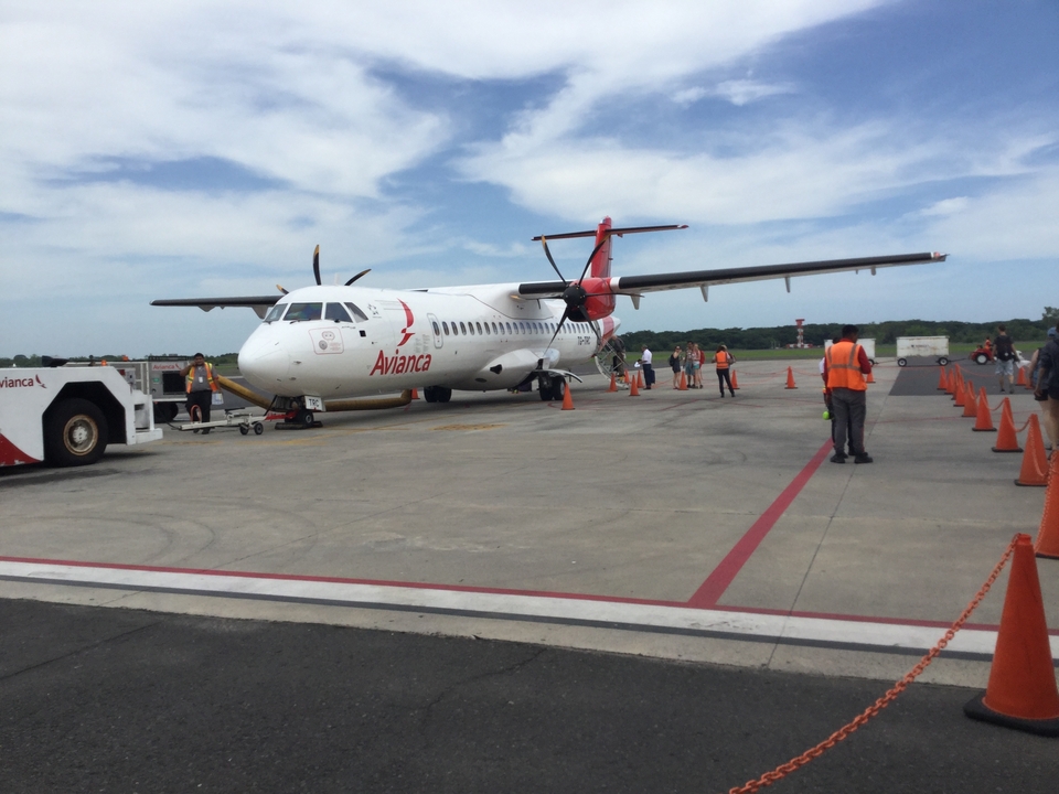 Avion commercial sur le tarmac avec le personnel au sol.