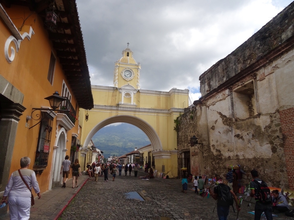 Une arche historique dans une ville animée où les gens se promènent.