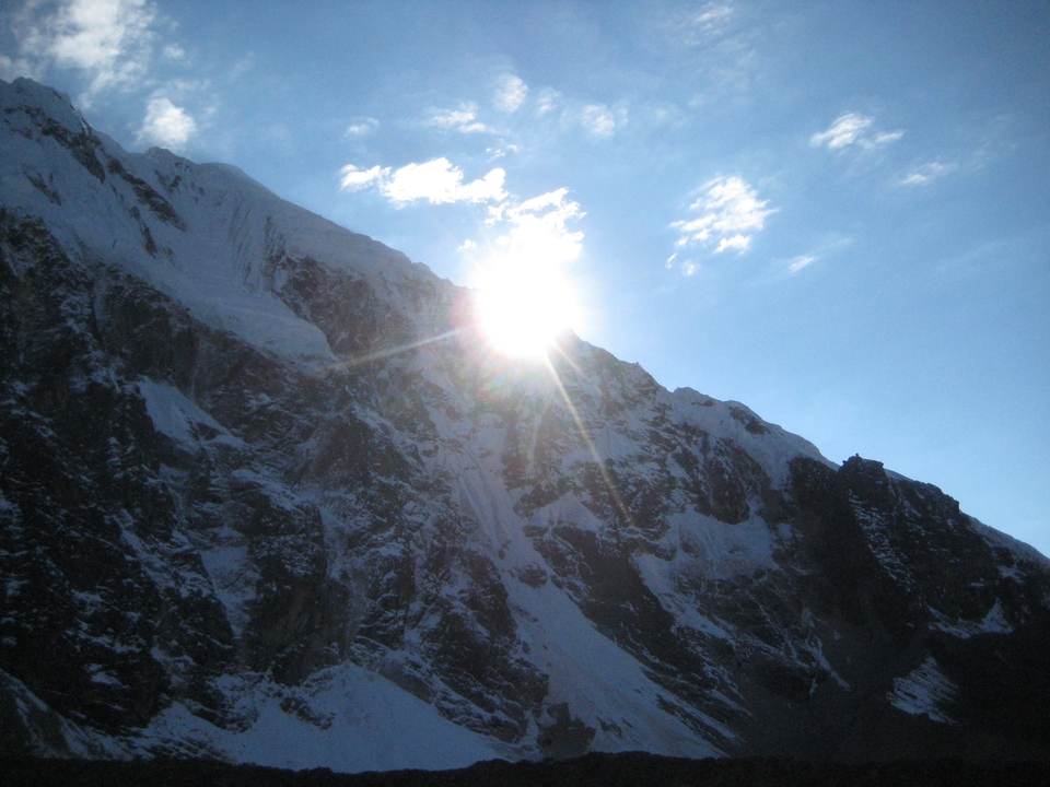 Le soleil brille sur les sommets enneigés des montagnes.