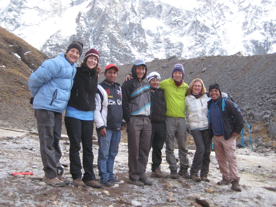 Groupe de randonneurs posant devant une montagne enneigée.