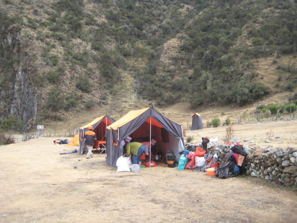 Tentes de camping dans une vallée entourée de montagnes.