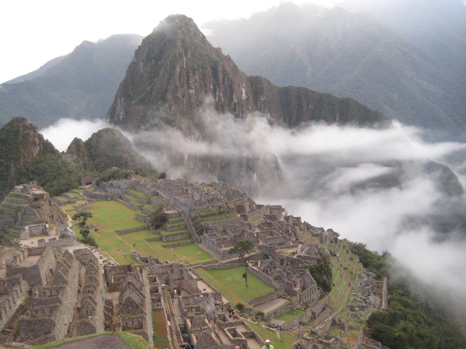 Vue panoramique du Machu Picchu avec brume et montagnes.