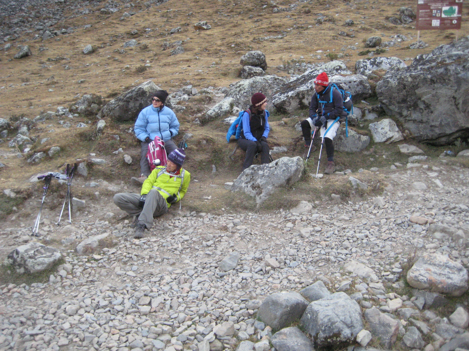 Randonneurs se reposant sur un sol rocailleux avec leur matériel de randonnée.