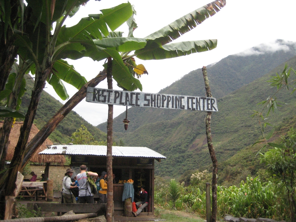 Des personnes sur une aire de repos avec un petit bâtiment dans une vallée luxuriante.