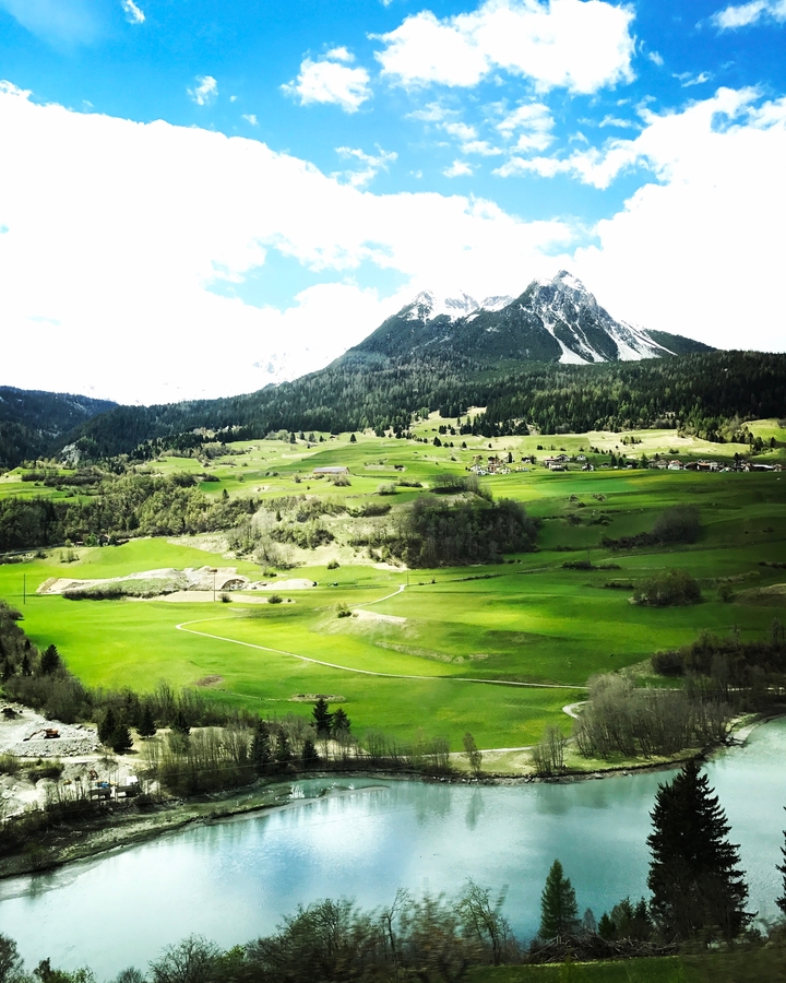 Vue panoramique sur les champs verdoyants et les montagnes.