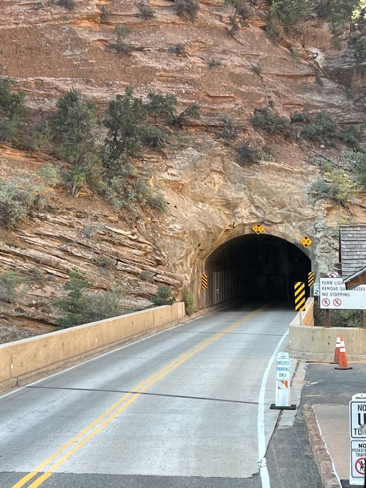 Une route menant à un tunnel rocheux.