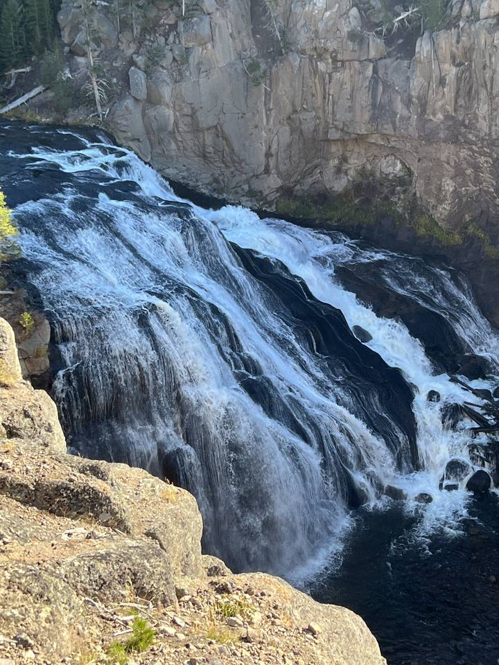Chute d'eau en cascade le long de falaises rocheuses.