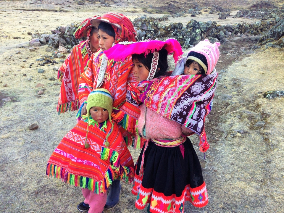 Enfants vêtus de vêtements traditionnels colorés en plein air.