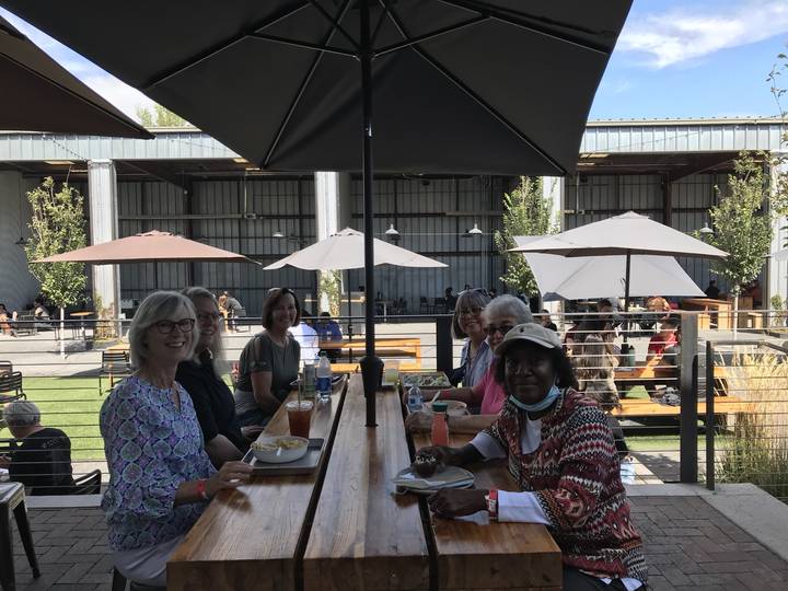 Des gens qui dînent dehors sous des parasols.