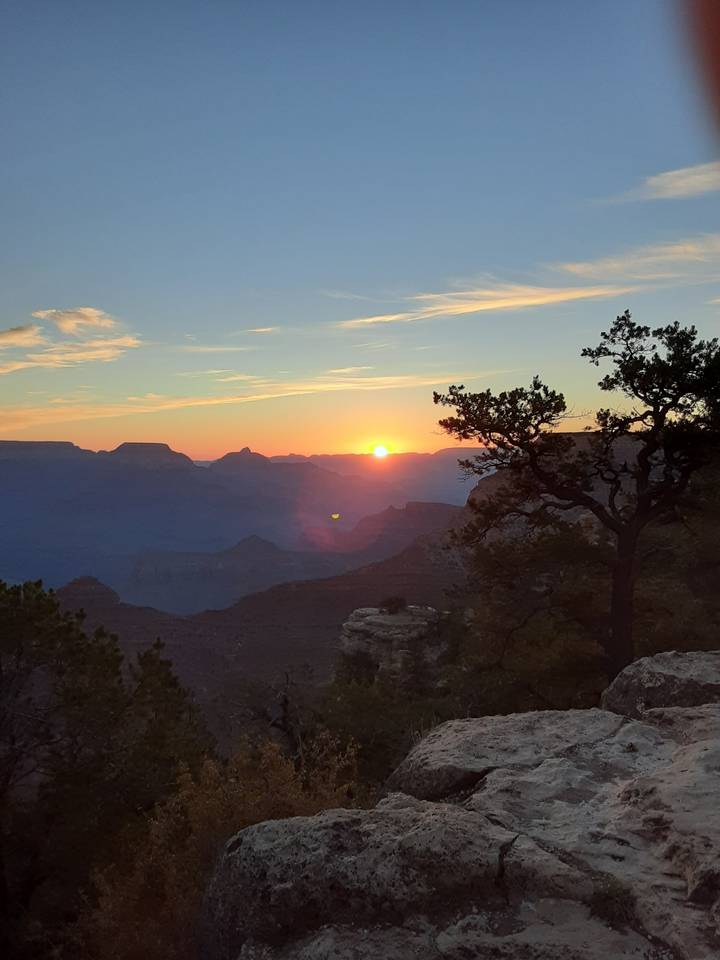 Coucher de soleil projetant de la lumière sur un paysage de canyon.