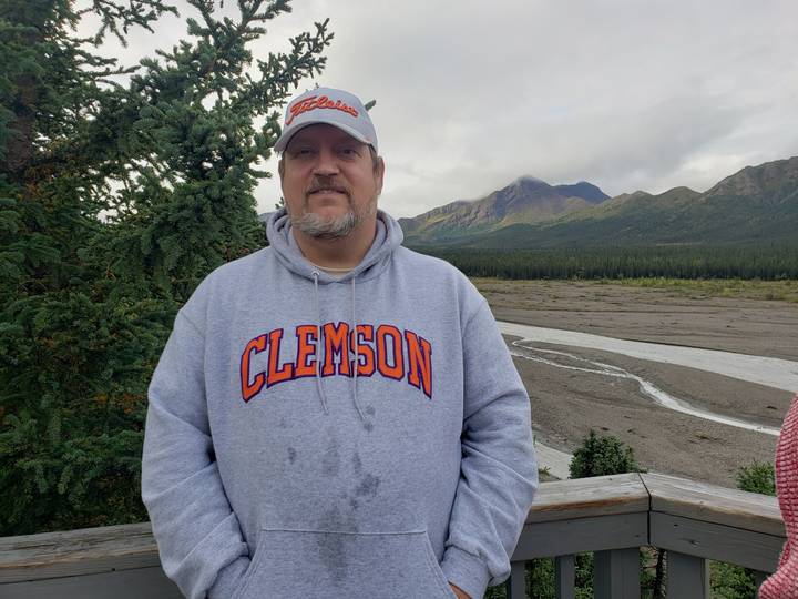 Personne la tête en bas dans un paysage avec des arbres et des montagnes.