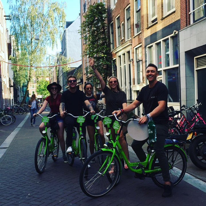 Groupe de personnes souriantes à vélo dans une rue de la ville.