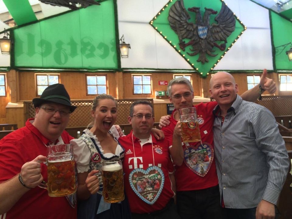 Des amis fêtant avec des boissons dans un cadre festif et portant des vêtements traditionnels.