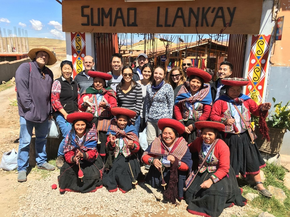 Groupe de personnes posant avec des habitants en tenue traditionnelle.