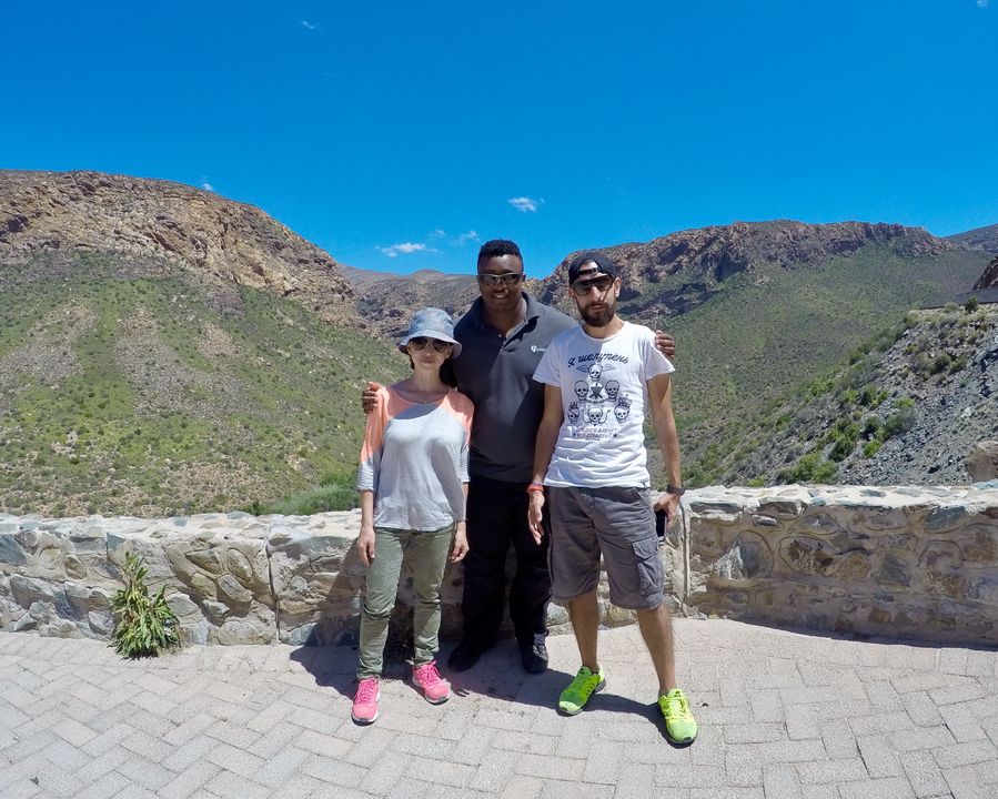 Trois personnes posant devant une vue de montagne.