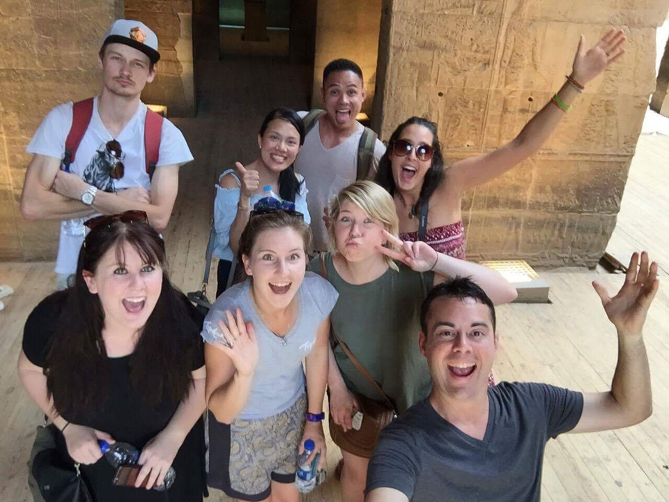 Tour group posing in front of an ancient structure.