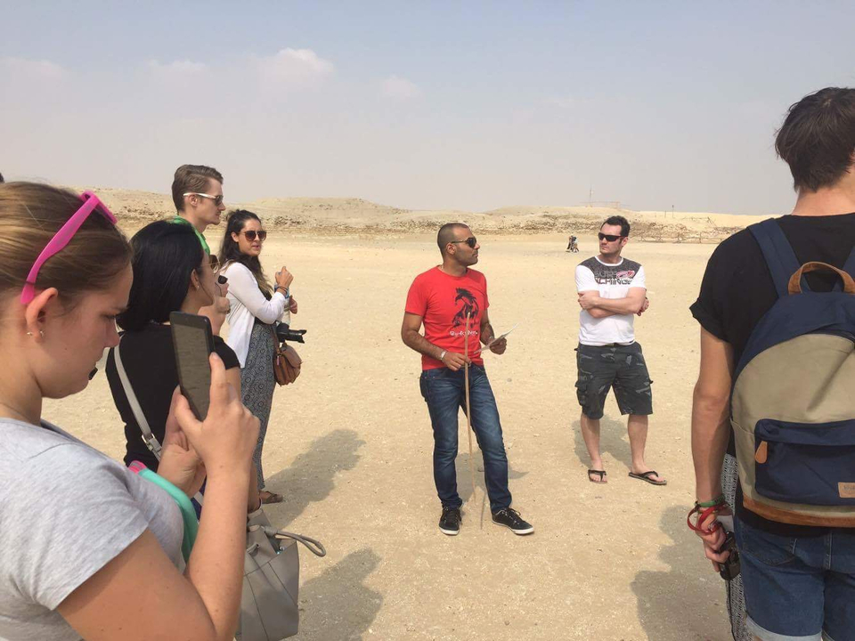Tour group receiving a guide in a desert setting.