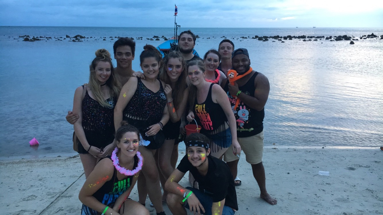Group photo on a beach with a party theme.