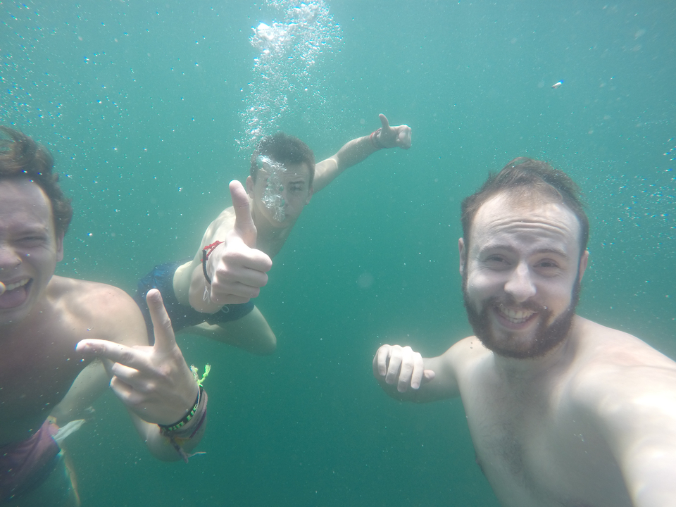 People posing underwater with thumbs up.
