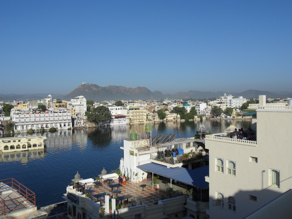 Panoramic view of Udaipur city and Lake Pichola with distant hills.