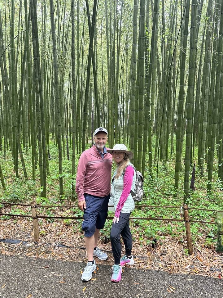 Deux personnes dans un décor de forêt de bambous.