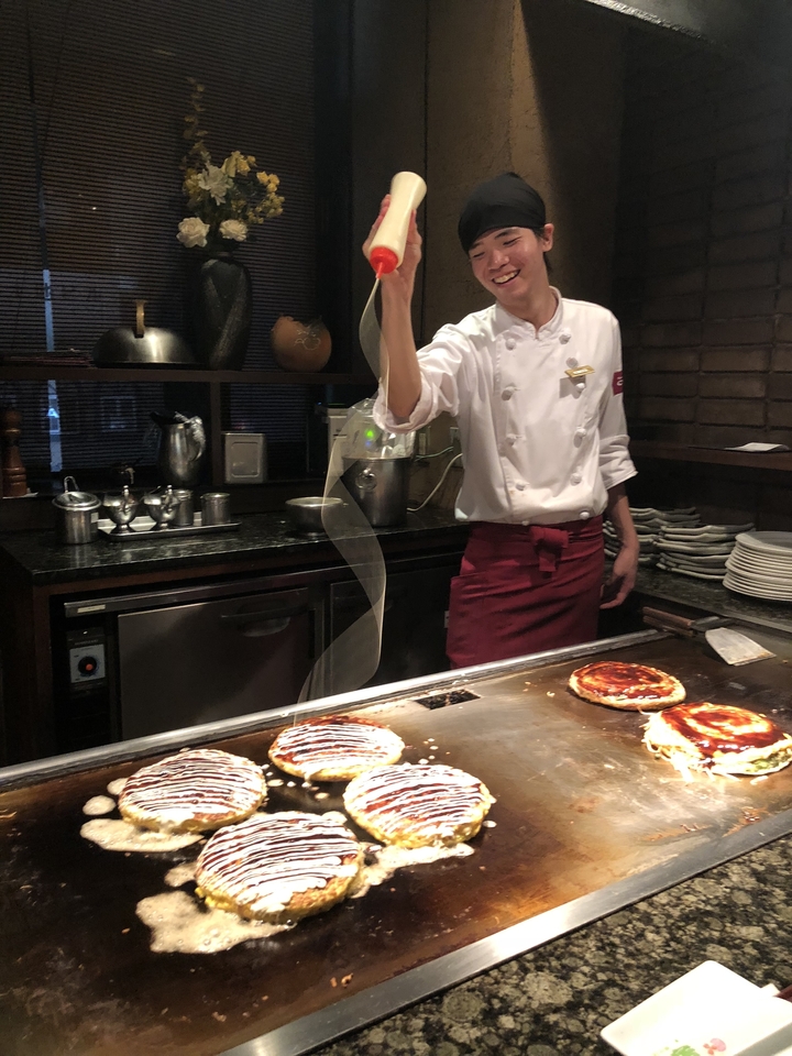 Chef préparant de la nourriture sur un grill teppan.