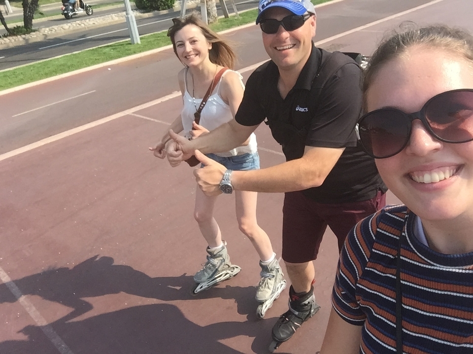 Trois personnes font du roller et sourient à l'appareil photo.