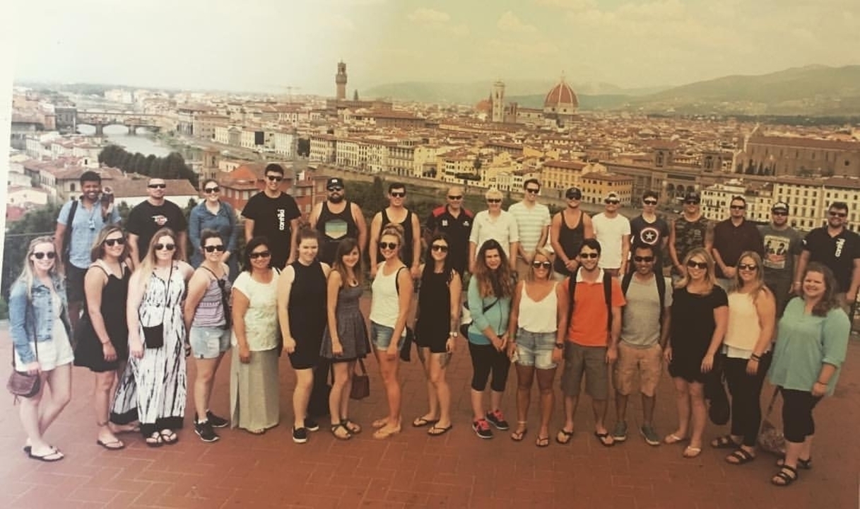 Grand groupe de personnes posant avec une vue du paysage urbain de Florence.