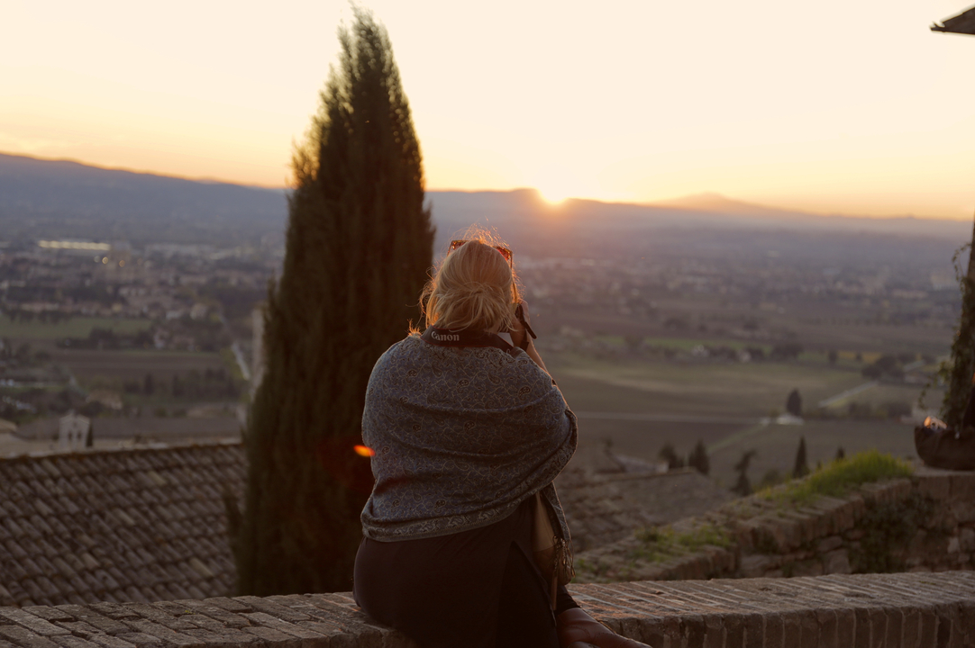 Personne observant un paysage au coucher du soleil.