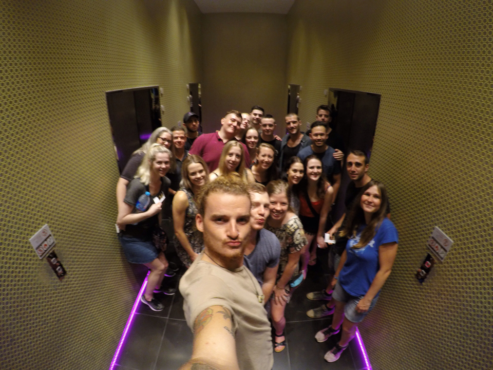 Large group of people in an elevator taking a selfie.