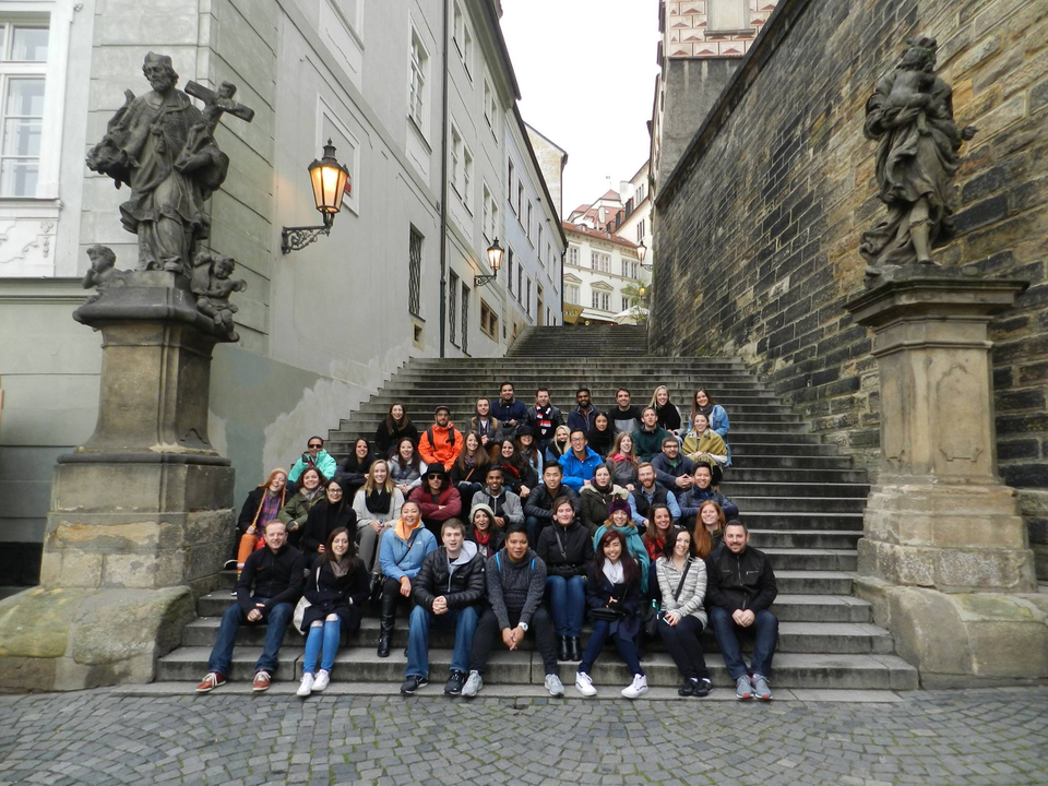 Grand groupe assis sur des marches en pierre avec des statues.