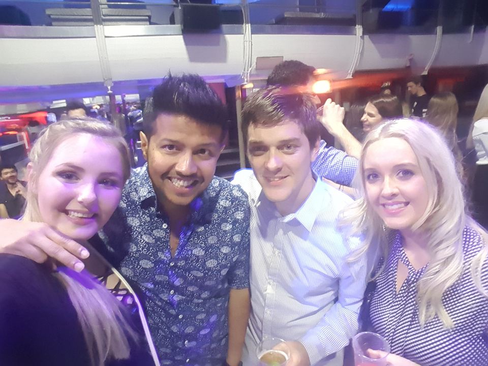Quatre personnes posant ensemble en intérieur dans une ambiance de fête.