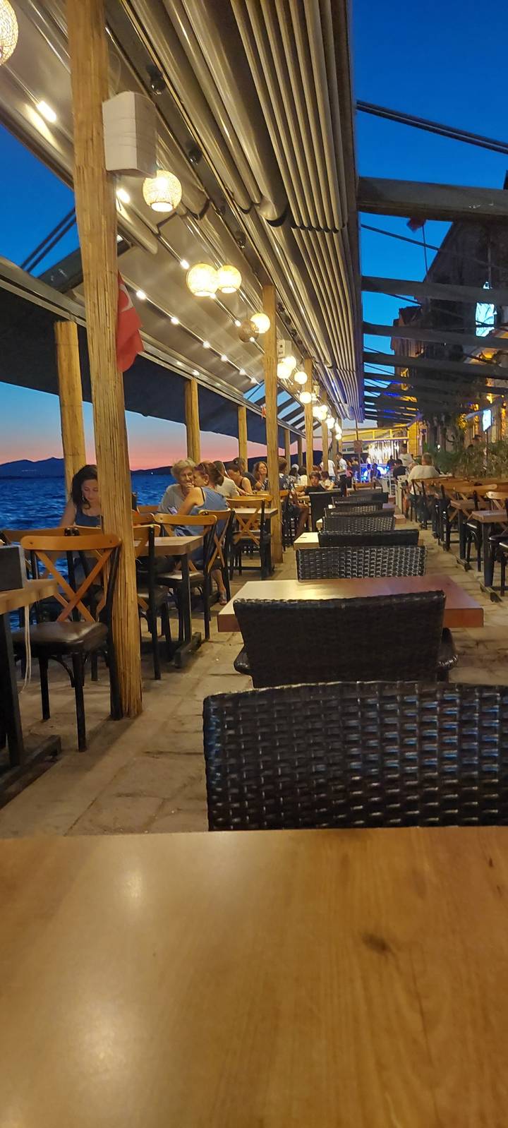 Des gens qui dînent dans un restaurant avec vue sur la mer.