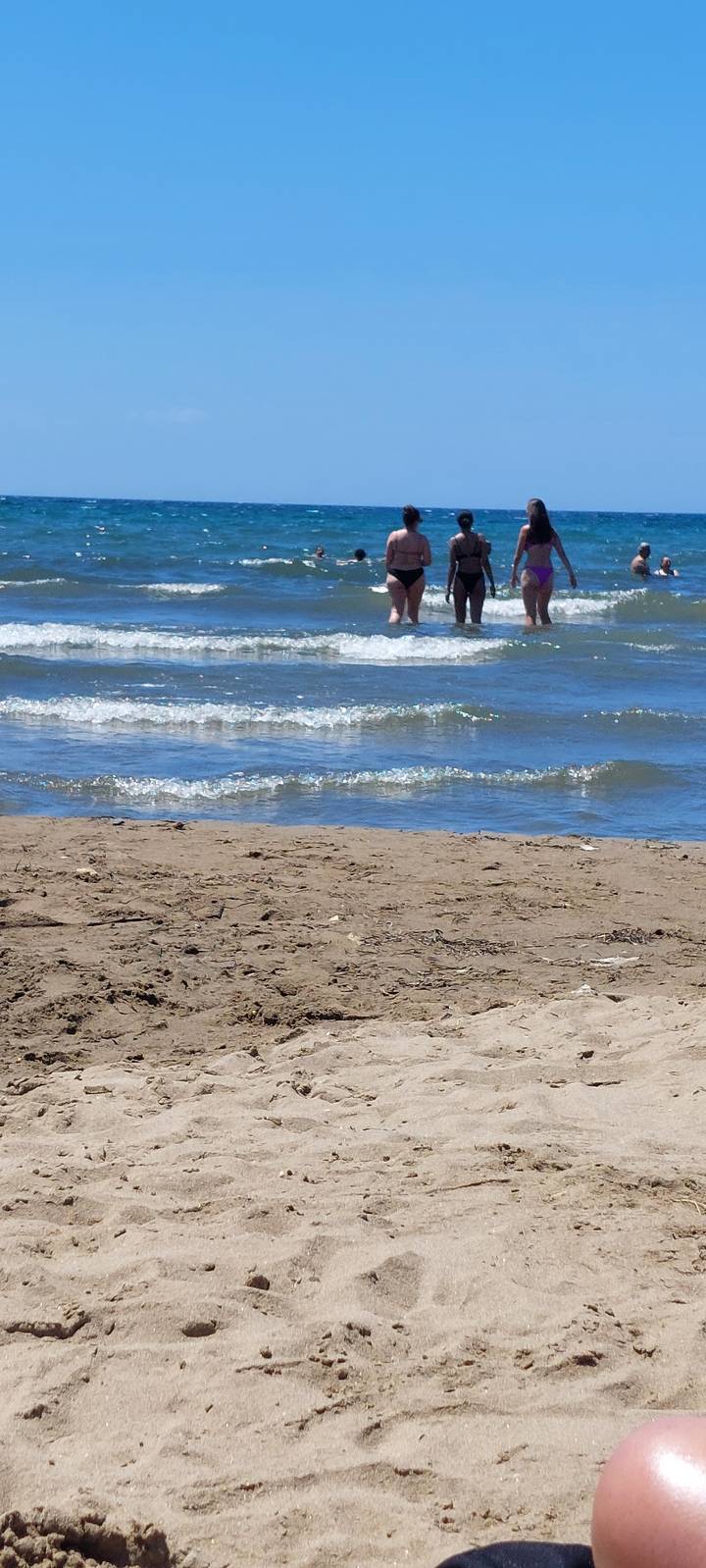 Des gens qui profitent de la plage et jouent dans l'océan.