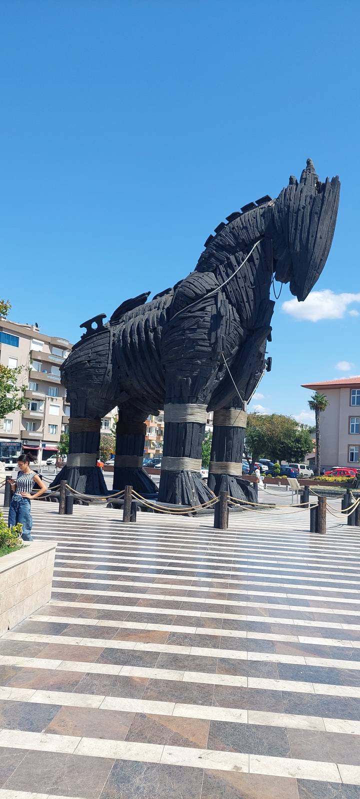 Une grande sculpture de cheval en bois dans une zone urbaine.