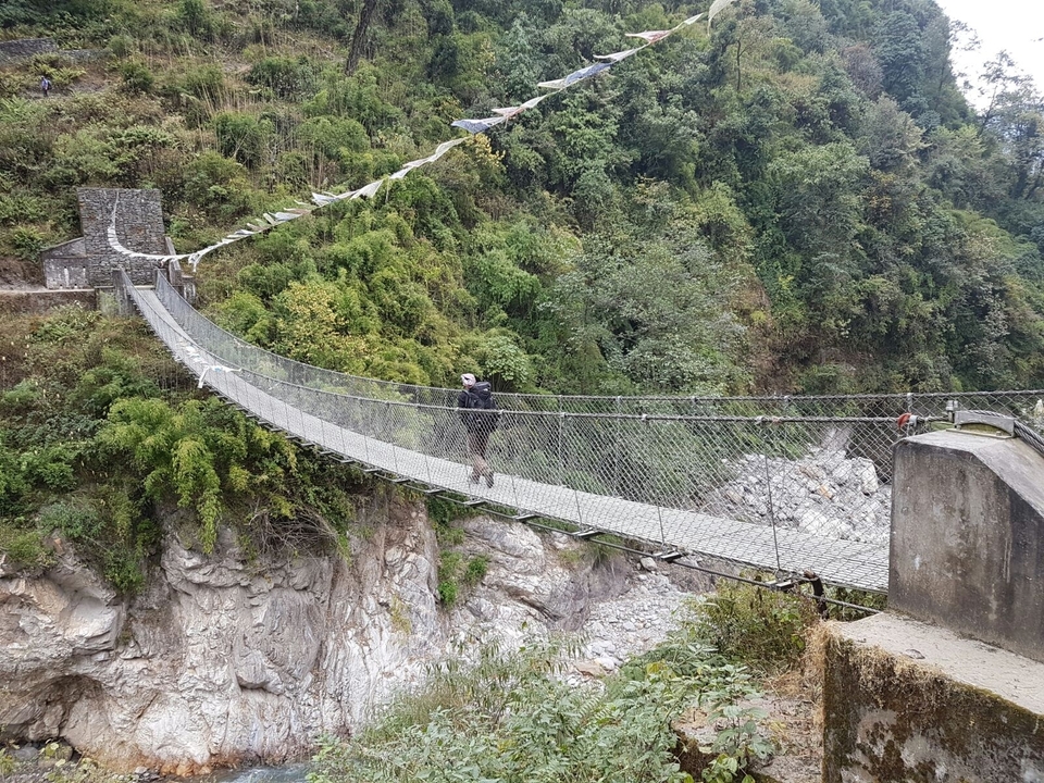 Pont suspendu traversé par une personne.