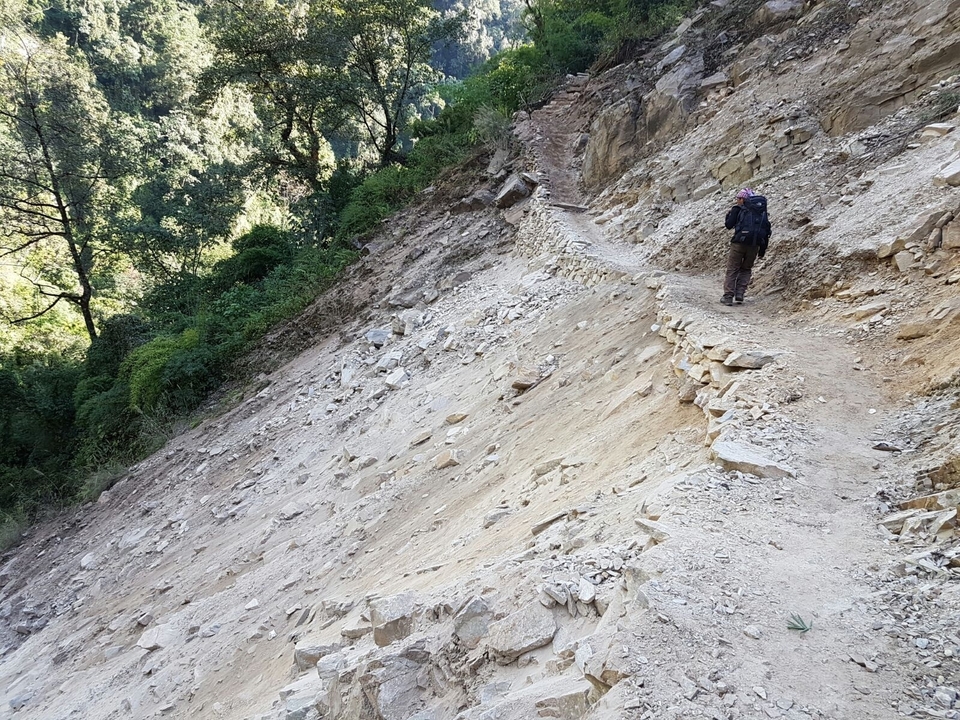 Personne faisant de la randonnée sur un sentier rocailleux.