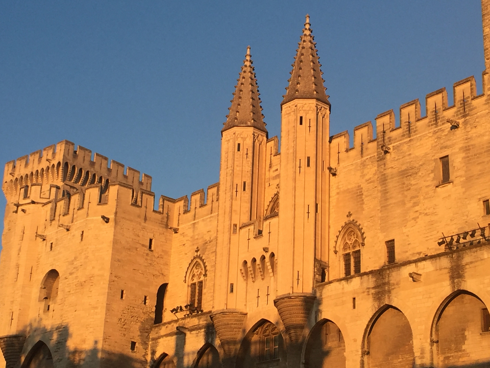 Historic building with pointed towers at sunset.