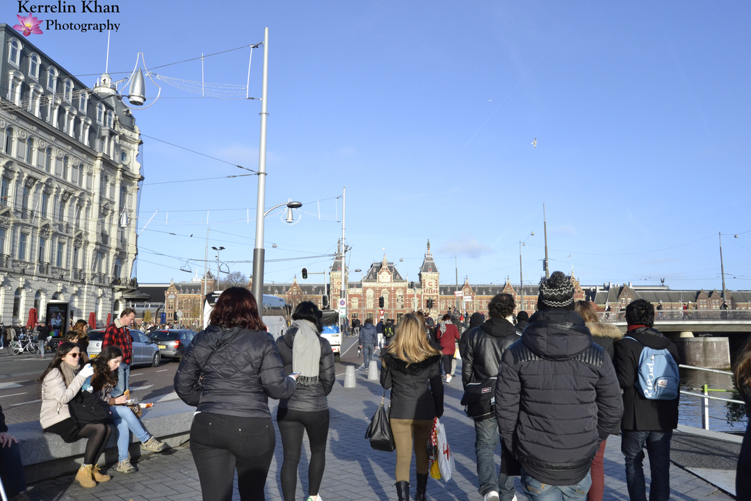 Scène de rue animée avec des gens qui marchent et font du vélo.