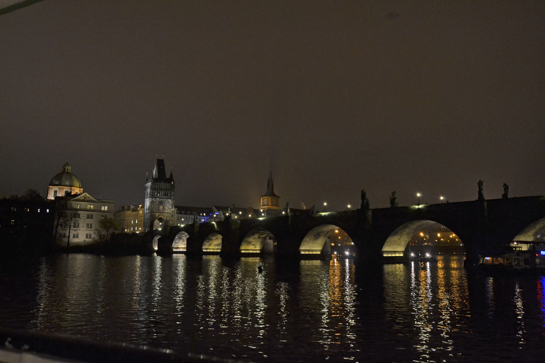 Pont Charles au-dessus de l'eau, illuminé la nuit.